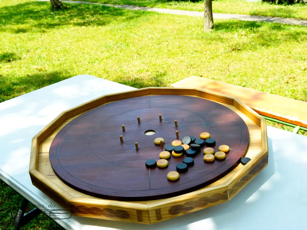 Le crokinole est un jeu de pichenette canadien. Il est ici prêt à jouer avec ses douzes palets en buis noir et blanc.