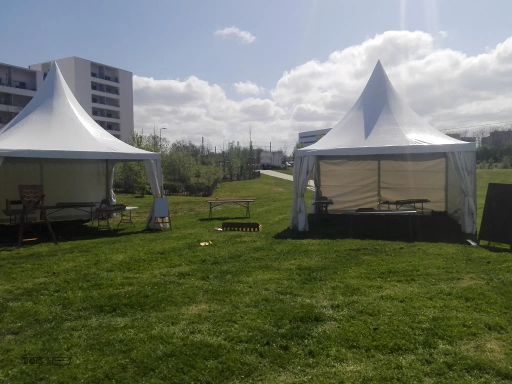 Avant le début de l'inauguration du Jardin des Acrobates à Toulouse en 2025, dix jeux en bois sont installés sous deux barnums.