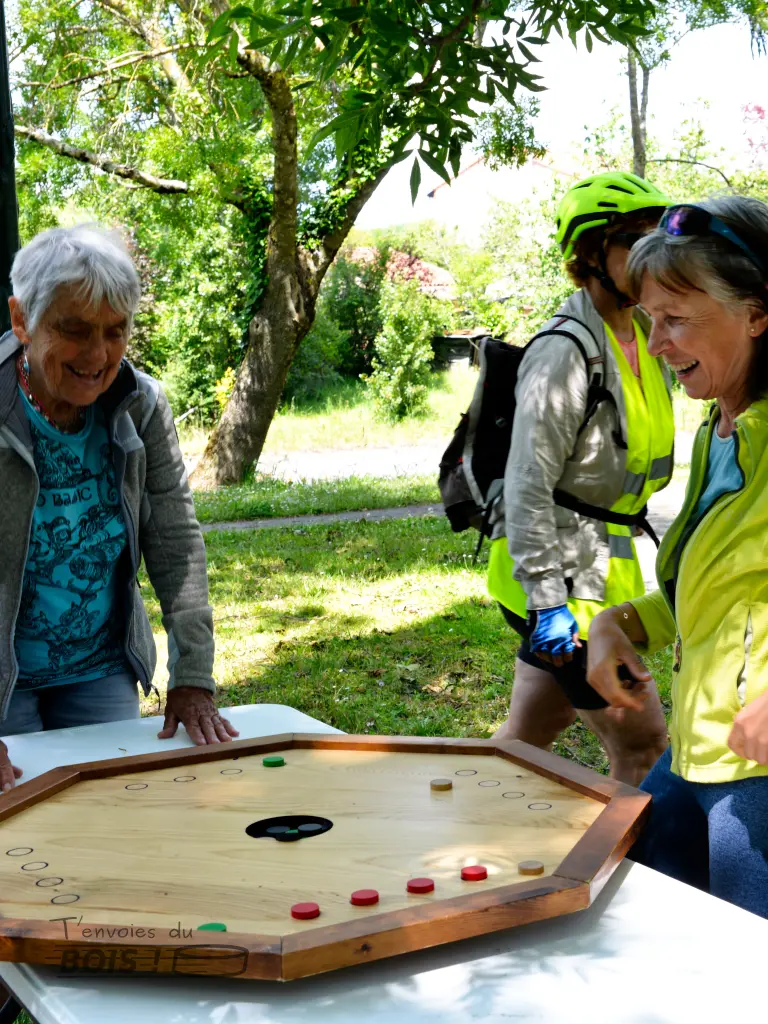 Des jeunes femmes jouent au trou noir dans une ambiance convivial. La scène se déroule dans un parc ensoleillé.