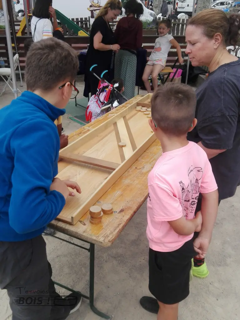 Un adolescent joue au billard hollandais sous le regard de sa famille. Photo prise lors de la transhumance de Seix en 2025.