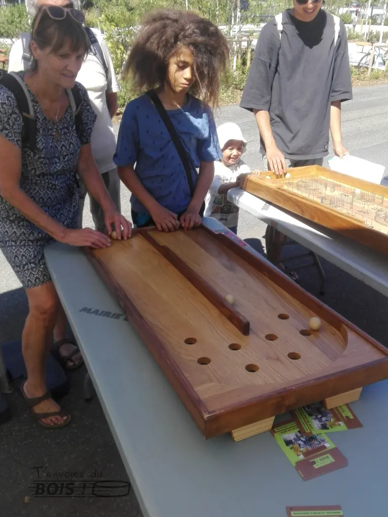 Une femme et un adolescent, avec beaucoup de cheveux, jouent ensemble au double chinois. Photo prise lors d'un inauguration sur la piste des géants à Toulouse en 2025.