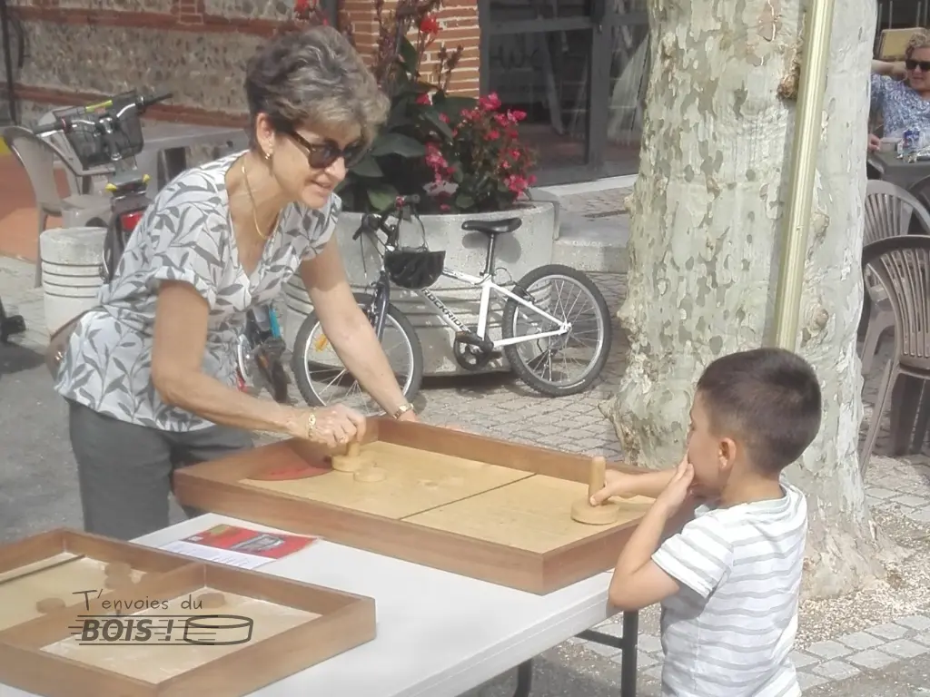 Une mamie et son petit-fils s'affrontent au hockey sur table. Scène capturée lors de la fête de Mauzac en 2025.