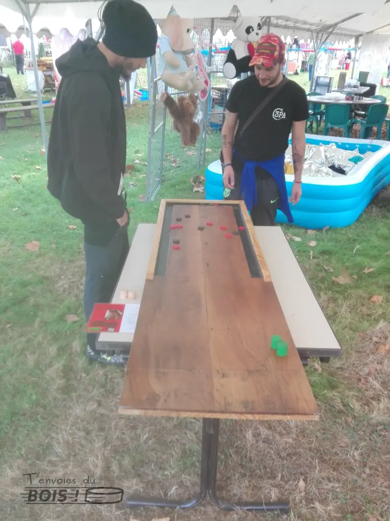 Le moment du décompte des points pour deux joueurs de jeu de galets. Ce jeu en bois traditionnel peut se jouer de 2 à 4 joueurs. Photo prise lors de la Route de la Récup à Saiguède en 2025.
