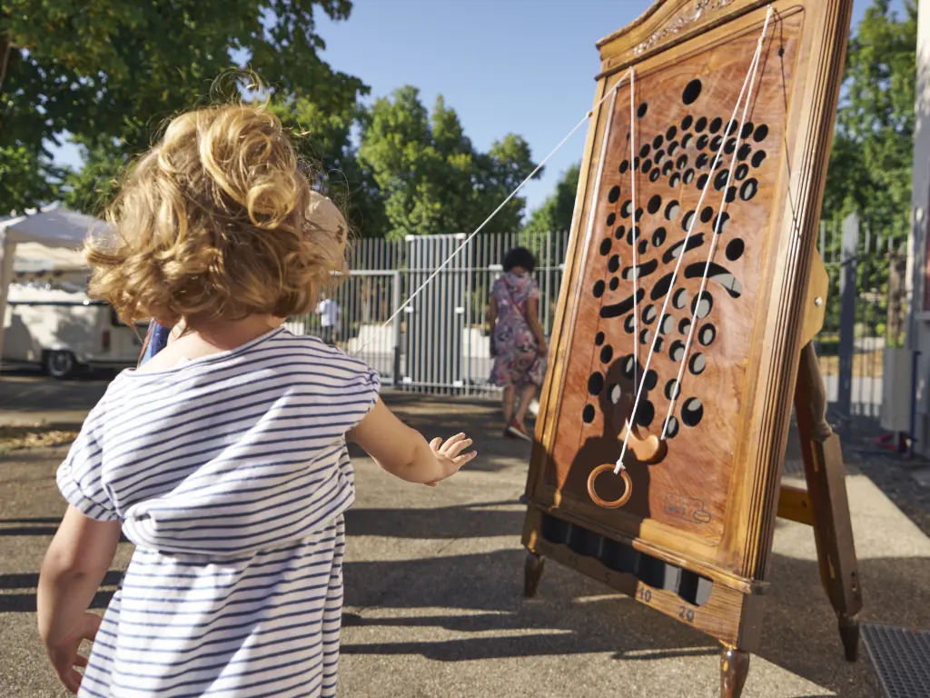 Un enfant lâche un anneau tenant la nacelle du jeu du gruyère. Photo prise pas Pierre Carton en 2025.