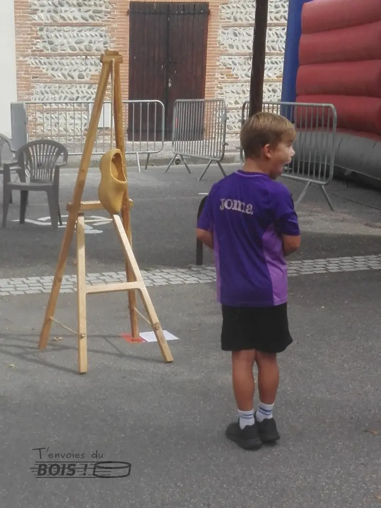 Regardez comme cet enfant s'extasie avec le jeu du sabot. Il n'en revient pas qu'il soit parvenu à mettre un palet dans le sabot. Photo prise lors de la fête de Mauzac en 2025.