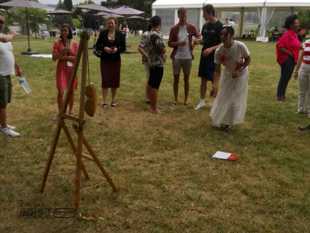 Un groupe de collègues sont autour du jeu du sabot alors qu'une femme s'apprête à lancer un palet. Scène capturée lors de la fête de l'INP en 2025.