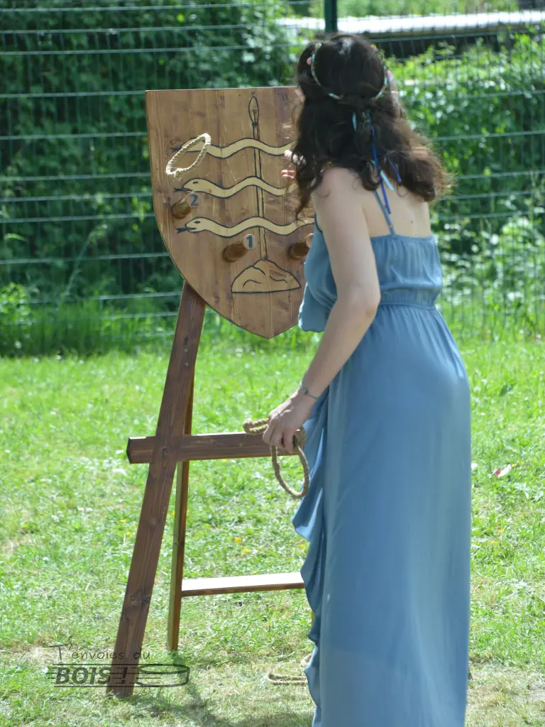 Une demoiselle joue au lancer d'anneau lors d'un festival médiéval. Photo prise lors du festival Échos & Merveilles en 2025.
