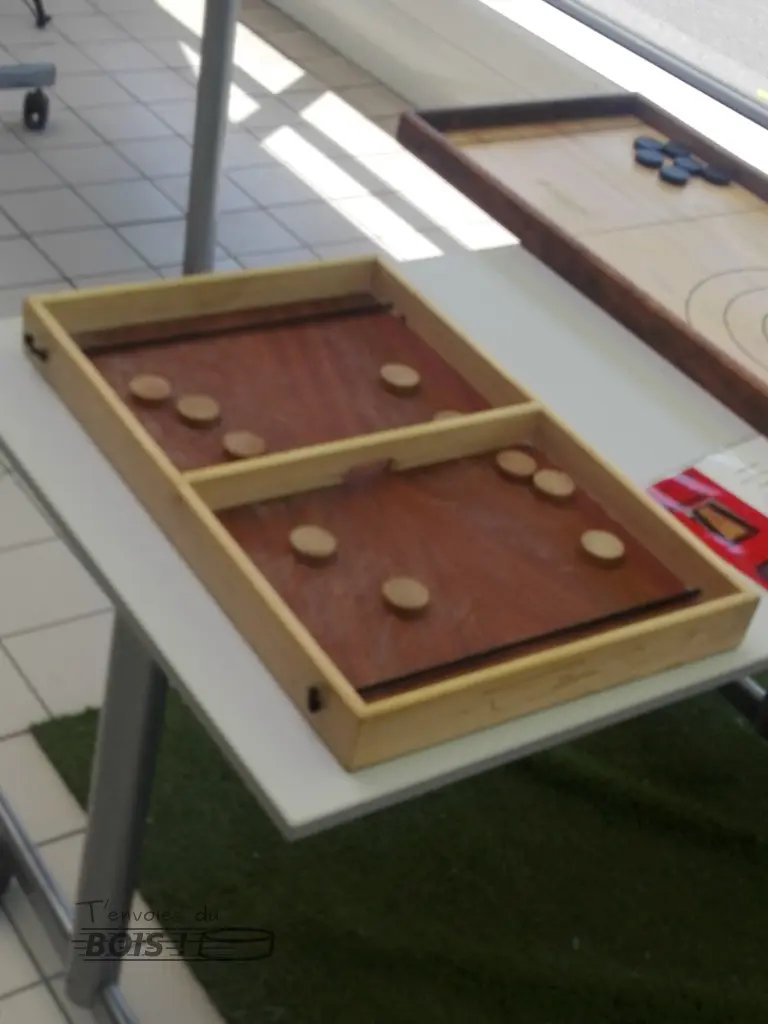 Le passe-trappe, aussi appelé table à élastique ou flitzer, est prêt à jouer avec ses 5 palets dans chaque camp. Photo prise lors d'un événement organisé par Leroy Merlin à Balma en 2025.