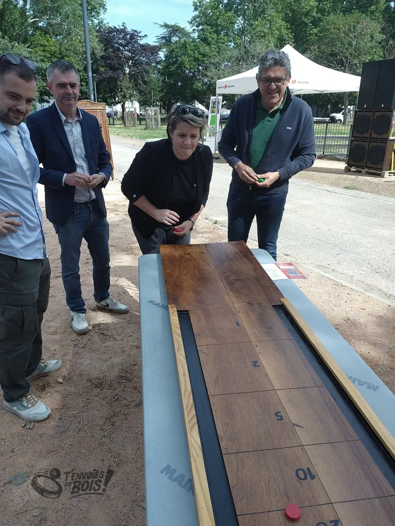 Un groupe de collègues joue les uns contre les autres au jeu de galets. Photo capturée lors de l'inauguration de la place André Daste à Toulouse en juin 2026.