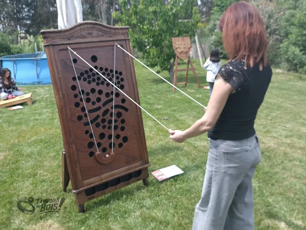 Une femme tente sa chance au jeu du gruyère. Photo prise lors d'une animation privée dans un jardin en 2026.