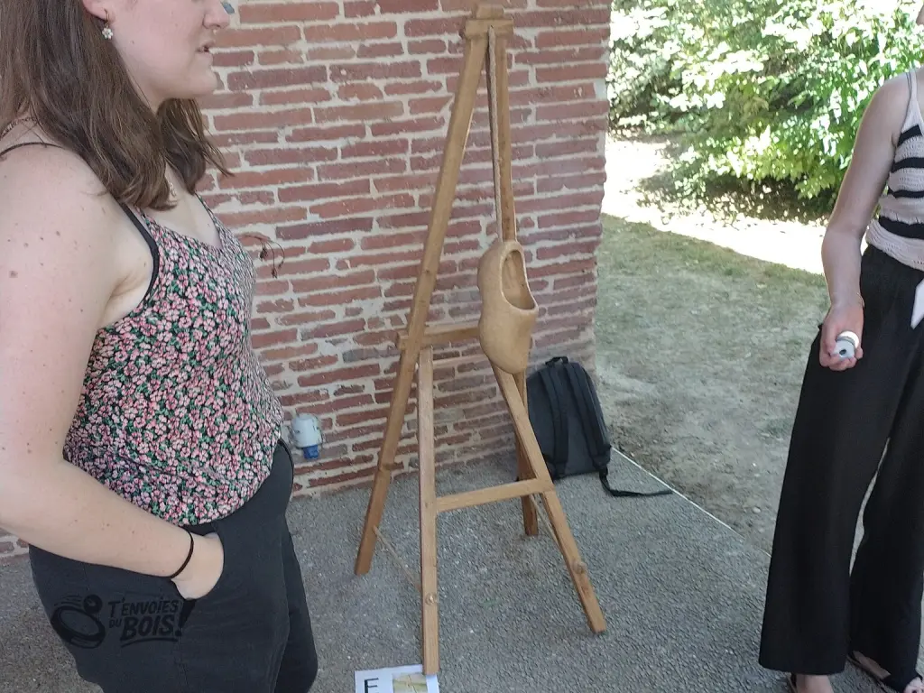 Un gros plan du jeu du sabot, la jeune fille à droite tient dans sa main les palets à lancer dans le sabot. Photo prise lors d'un séminaire du CNRS en juin 2026.