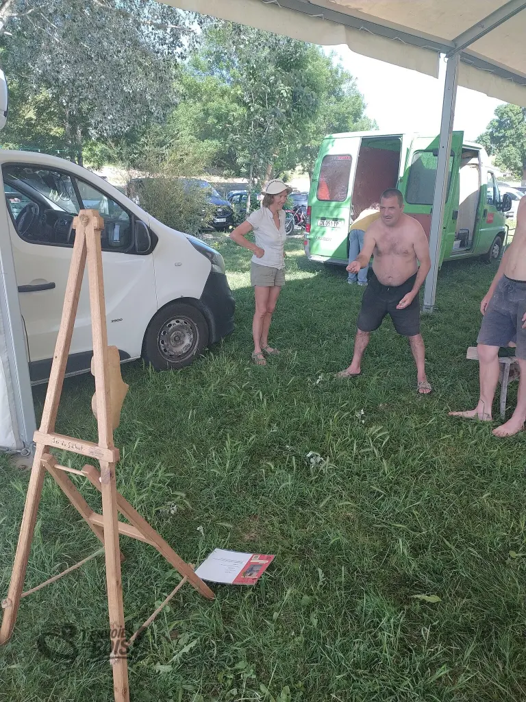 Un homme s'apprête à lancer un palet dans le sabot sur le jeu du sabot. Scène capturée à St-Ybars lors de la Fête de la Nature en 2026.