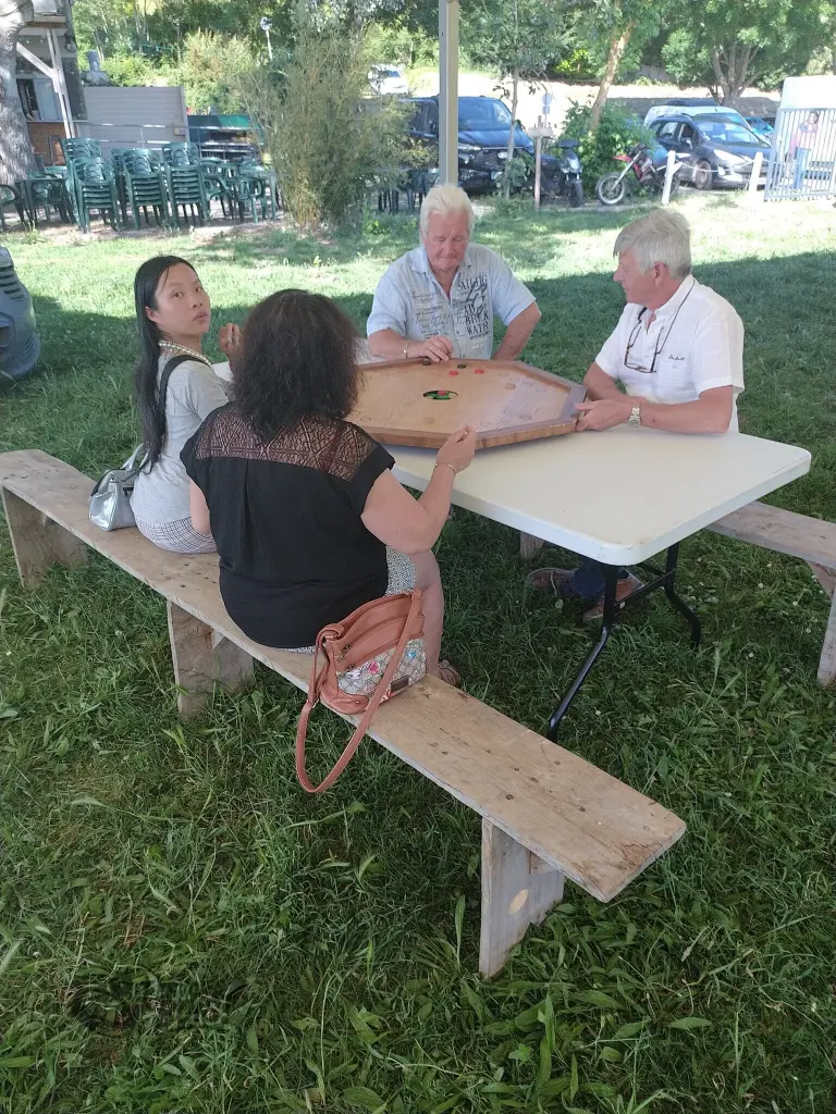 Un groupe de personnes joue au trou noir dans un cadre verdoyant. Photo prise en Ariège en 2026.